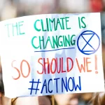Cartel The climate is changing en manifestación por la reducción de las emisiones contaminantes