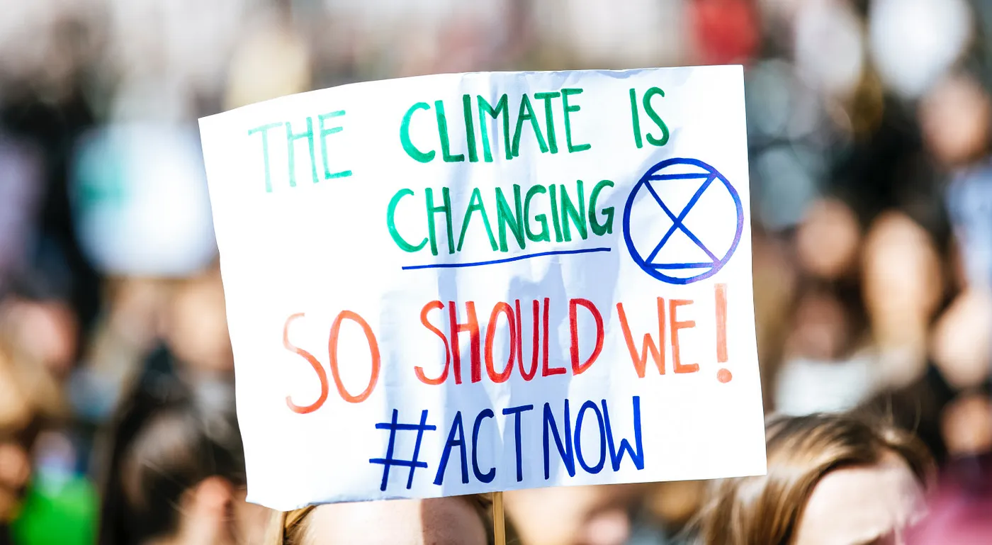 Cartel The climate is changing en manifestación por la reducción de las emisiones contaminantes